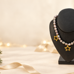 Collier en perles de culture grises et trois étoiles dorées dans un décor de Noël