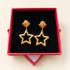 Boucles d’oreilles étoiles dorées présentées dans leur boîte rouge
