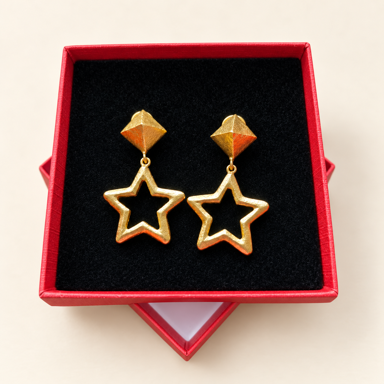 Boucles d’oreilles étoiles dorées présentées dans leur boîte rouge